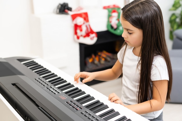 menina tocando piano elétrico no natal