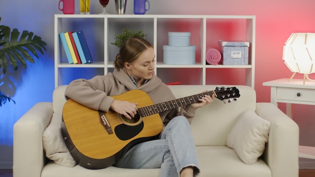 Menina tocando violão em casa Músico feminino aprendendo a tocar instrumento musical na vida