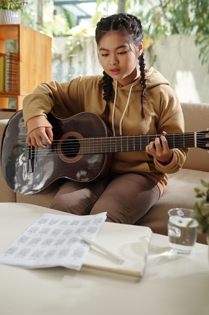 Menina tocando violão em casa