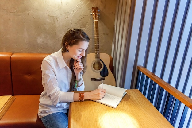 Menina tocando violão no café