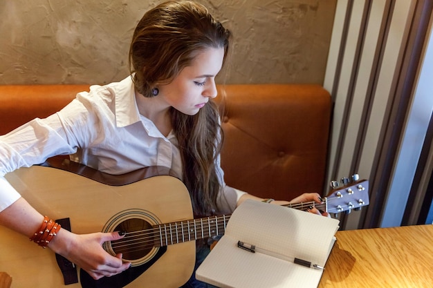 Menina tocando violão no café