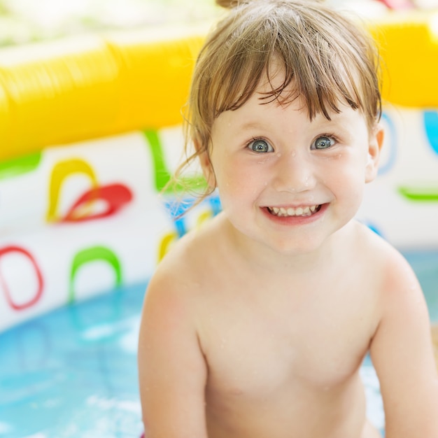 Menina tomando banho em uma piscina inflável