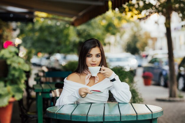 Menina tomando café e sorrindo