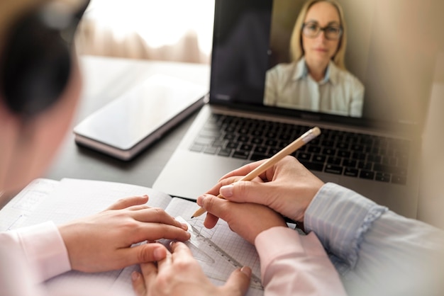 Menina tomando notas enquanto fazia uma aula on-line