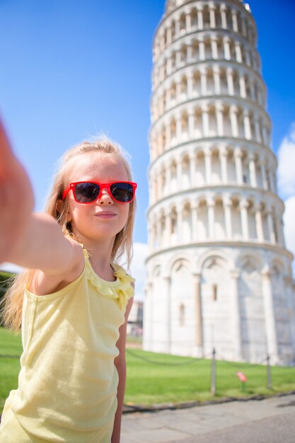 Menina tomando selfie com torre em pisa, itália