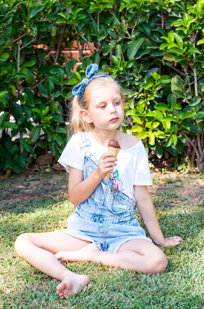 Menina tomando sorvete de chocolate ao ar livre