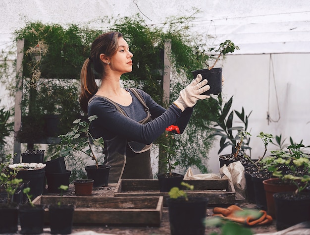 Foto menina trabalhando no jardim com mudas em vasos