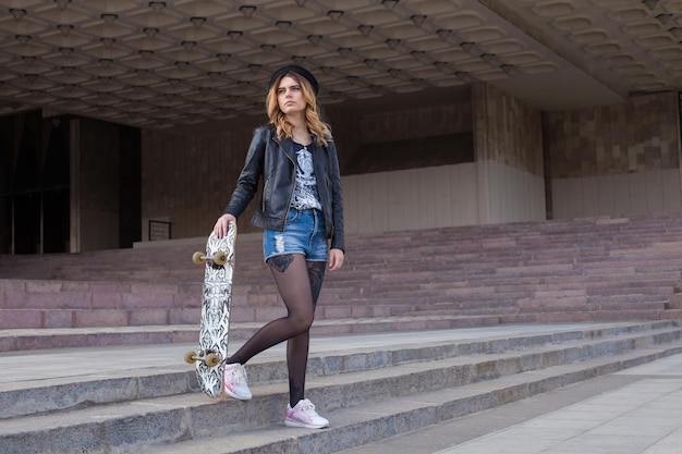 Menina triste com o skate descendo as escadas