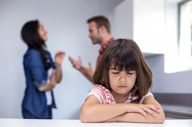 Foto menina triste ouvir seus pais discutindo