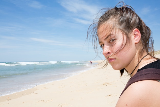 Menina tristeza na praia do mar de areia no horário de verão