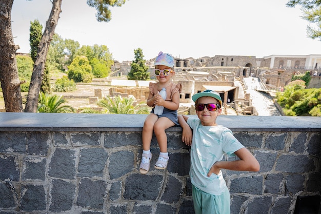 Menina turista com irmão contra vista panorâmica da antiga cidade de Pompéia