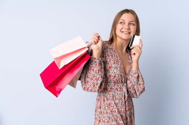 Menina ucraniana adolescente segurando sacolas de compras e um cartão de crédito