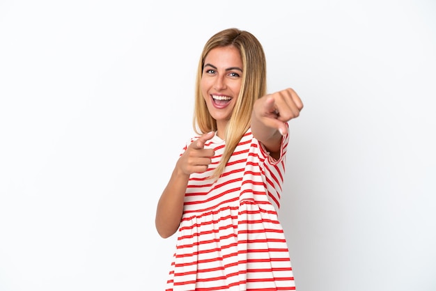 Menina uruguaia loira isolada em um fundo branco apontando para a frente e sorrindo