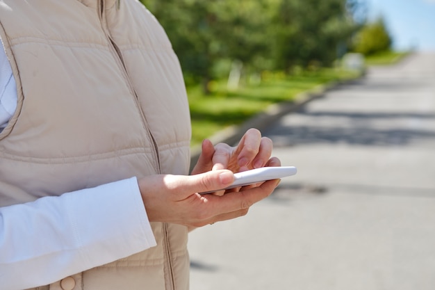 Menina usa um smartphone enquanto caminhava na rua.