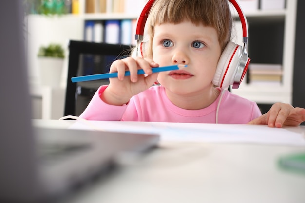 Menina usando fones de ouvido usar computador móvel