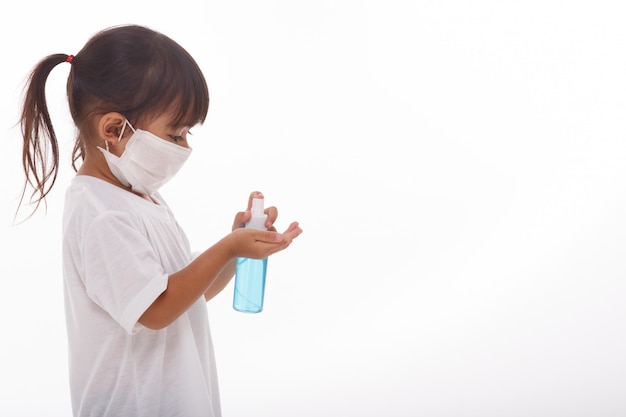 Menina usando gel de álcool para limpar as mãos.