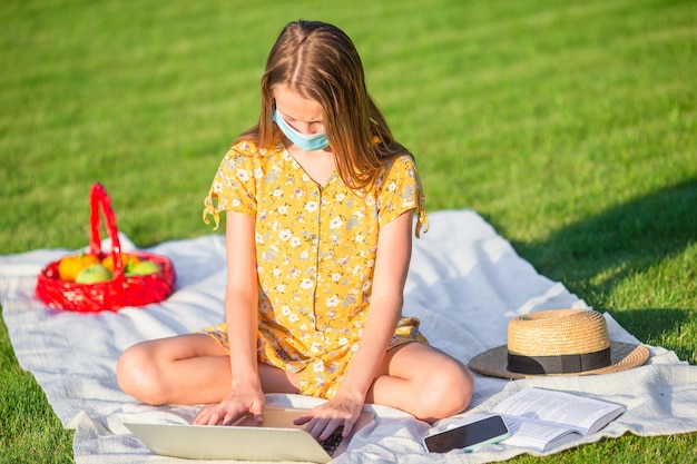 Menina usando laptop para estudar ao ar livre no parque