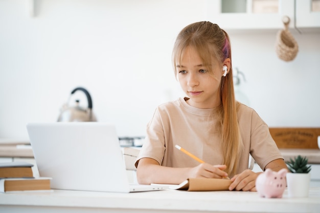 Menina usando laptop para fazer o dever de casa em casa