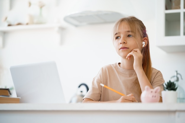 Menina usando laptop para fazer o dever de casa em casa