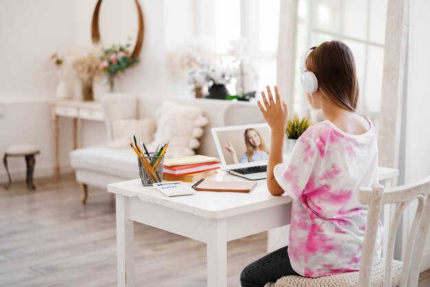 Menina usando laptop para fazer o dever de casa em casa