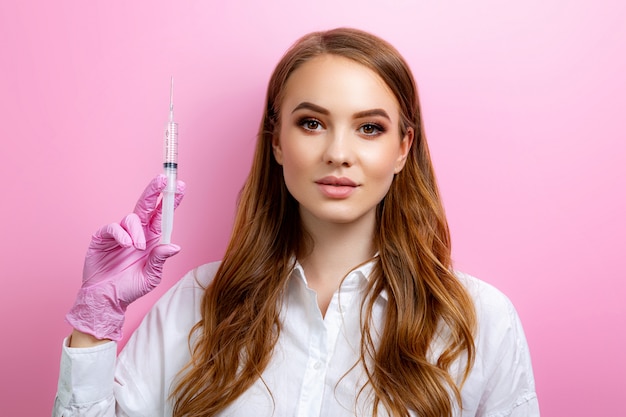 Foto menina usando luvas de cirurgia e segurando uma seringa