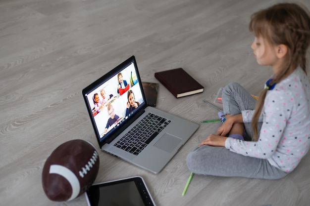 Menina usando o bate-papo por vídeo no laptop em casa. Espaço para texto