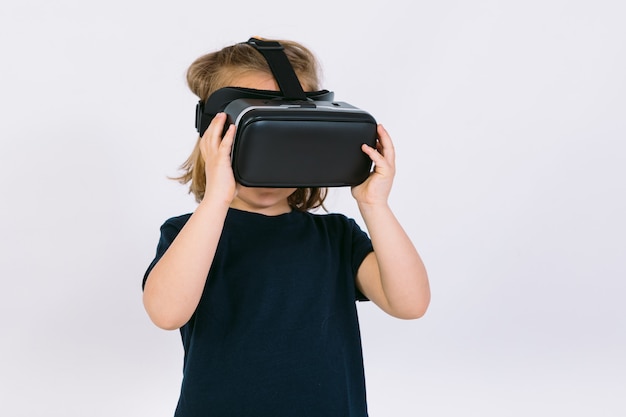Menina usando óculos de realidade virtual com as mãos segurando óculos de proteção no fundo branco
