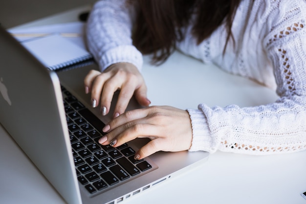 Menina usando seu laptop em sua casa.