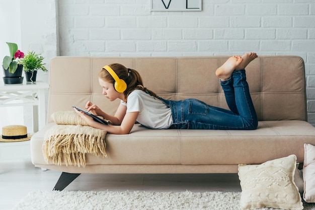 Menina usando tablet digital em casa