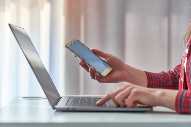 Foto menina usando um smartphone e laptop