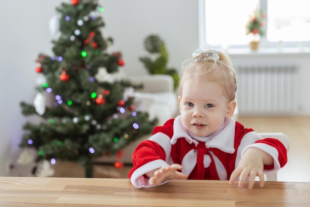 Menina vestida com vestido de natal com implantes cocleares se divertindo em casa diversidade e ouvido