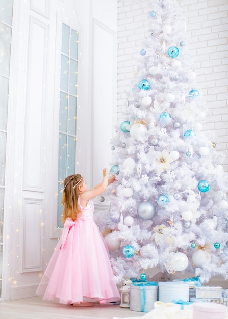 Menina vestido elegante, decoração enorme árvore de Natal branco