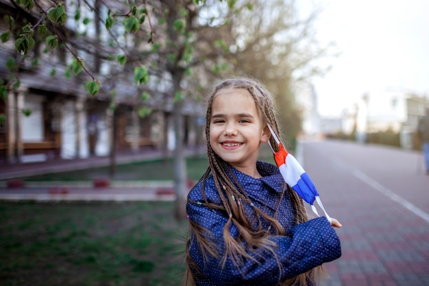 Menina vestindo a máscara médica do respirador nas cores nacionais da França