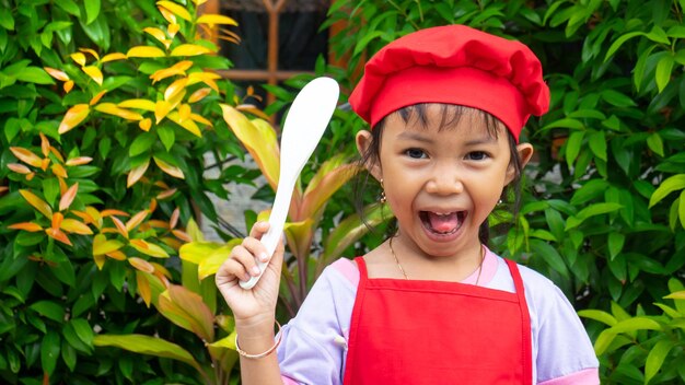 Menina vestindo roupas de cozinha vermelhas