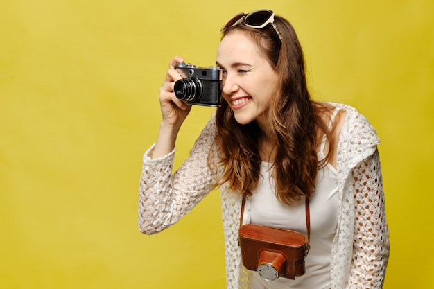 Menina viajante tira fotos com uma câmera vintage.