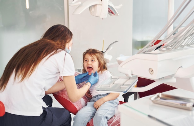 Menina visitando dentista na clínica Concepção de estomatologia