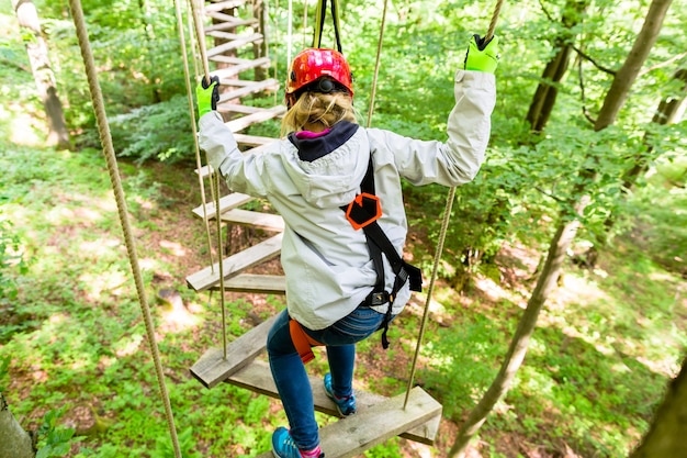 Menina vista de cima escalando em corda alta