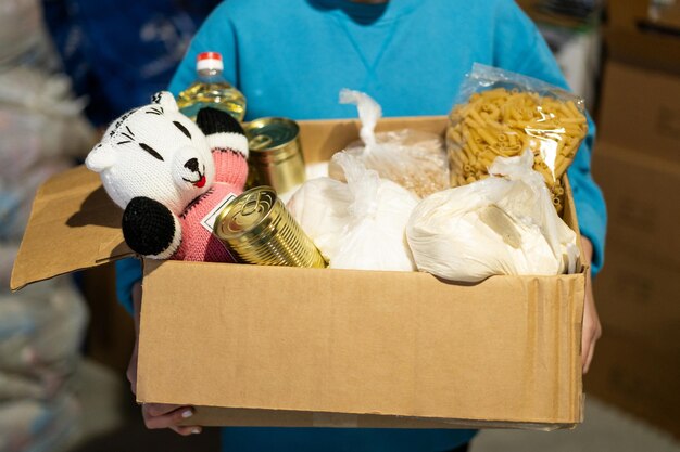 Menina voluntária preparando caixas de doação para pessoas doação de roupas para refugiados apoio às vítimas da guerra conceito de ajuda humanitáriaajudando as pessoas