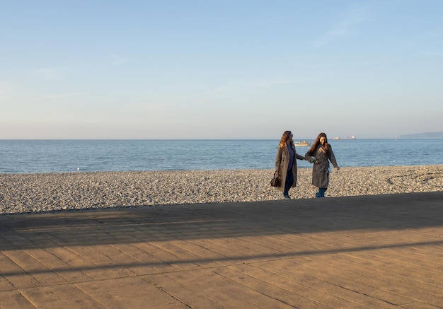 Meninas à beira-mar em clima frio Primavera na praia de pedra do sul