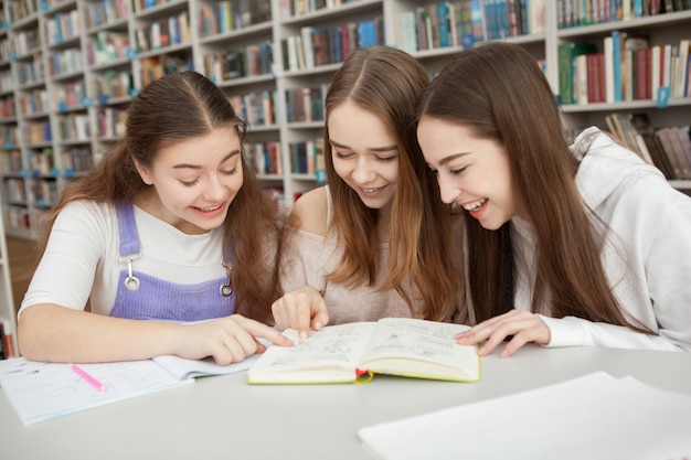 Meninas adolescentes estudando juntas na biblioteca