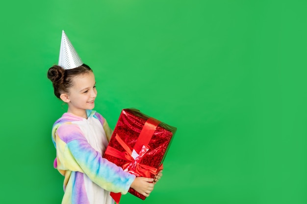 Meninas alegres com uma fantasia de unicórnio em um fundo verde