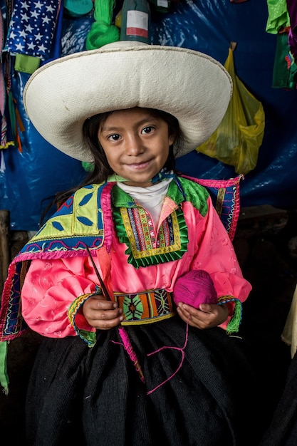 Meninas andinas peruanas fazendo tecelagens e posando em suas cidades e casas com roupas coloridas