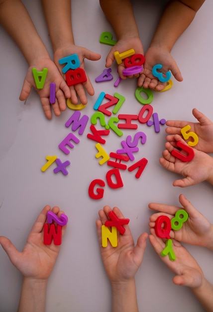 Meninas aprendendo o alfabeto usando letras coloridas, vista superior