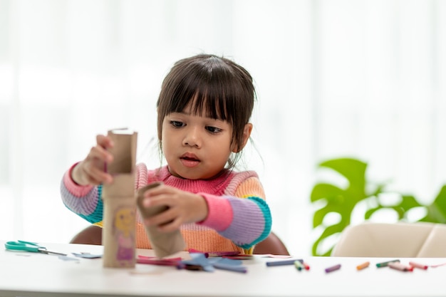 Meninas asiáticas estão fazendo binóculos com núcleo de papel de seda reutilize produtos residuais ideia de brinquedo personalizado foco suave