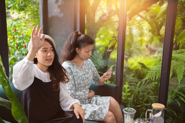 Meninas bebem café relaxam no café Freelancer se comunica no projeto meninas fazendo compras on-line no tablet wifiEstudantes na internetProcesso de negócios de trabalho