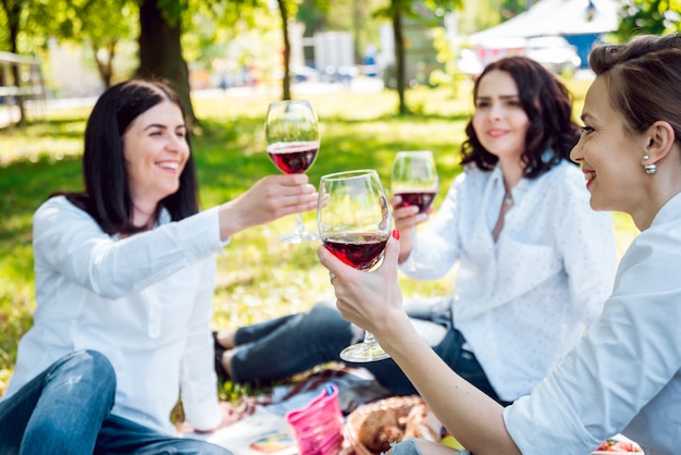 Meninas bonitas com copo de vinho tinto no parque