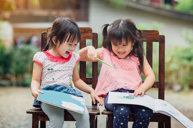 Meninas brincando com livros para colorir