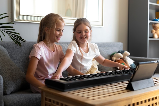 Foto meninas brincando de teclado em casa