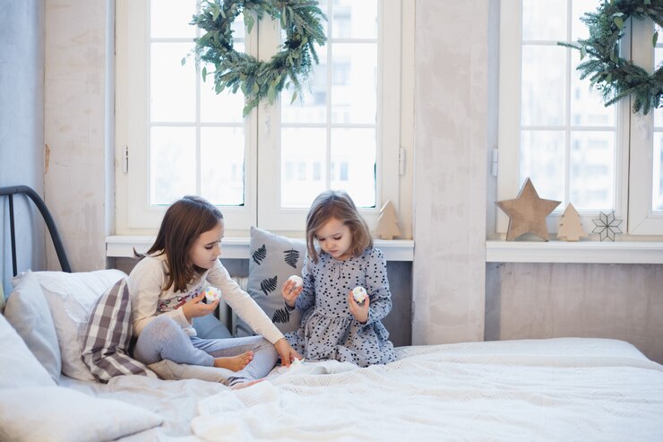 Meninas brincando em casa na cama durante o natal