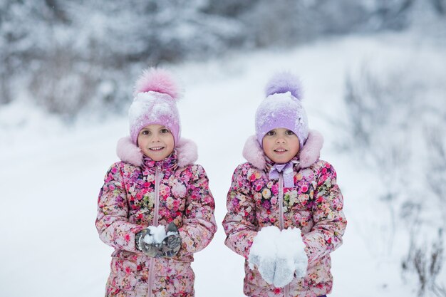 Meninas brincando no parque de inverno com neve